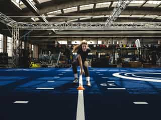 Sportlerin beim Sprint- und Koordinationstraining mit Hütchen in der Trainingshalle von Physiosport Köln.