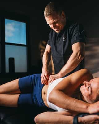 Physiotherapeut von Physiosport Köln mobilisiert Hüftmuskulatur einer Patientin.