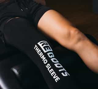 Patientin liegt auf Liege und erhält Ganzbein-Kältetherapie bei PhysioSport Köln im Rahmen der Physikalischen Therapie.