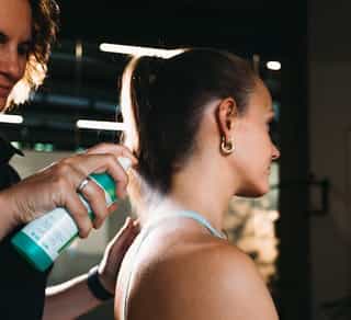 Patientin bei PhysioSport Köln, Therapeutin reinigt den Nackenbereich mit Desinfektionsmittel für gezielte Dry Needling Behandlung.