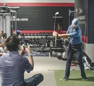 Zu sehen ist ein Golfspieler und ein externer Trainer beim Training mittels TPI-Golfscreening durch PhysioSport Köln zur Verbesserung seiner Leistung.