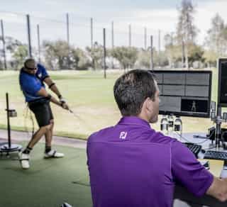 Zu sehen ist ein Golfspieler und ein externer Trainer beim Training auf einer Golfanlage zur Verbesserung seiner Leistung mittels TPI-Golfscreening durch PhysioSport Köln.