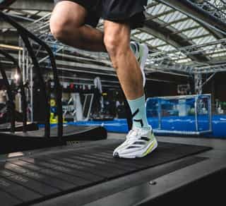 Zu sehen ist ein Sportler auf einem Laufband bei Physiosport Köln. In Nahaufnahme das Knie.