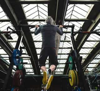 Sportler trainiert Klimmzüge an den Geräten von Physiosport Köln.