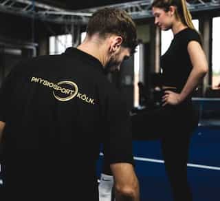 Trainer von PhysioSport Köln mit einer Sportlerin bei Koordinationstraining nach Patellaluxation.