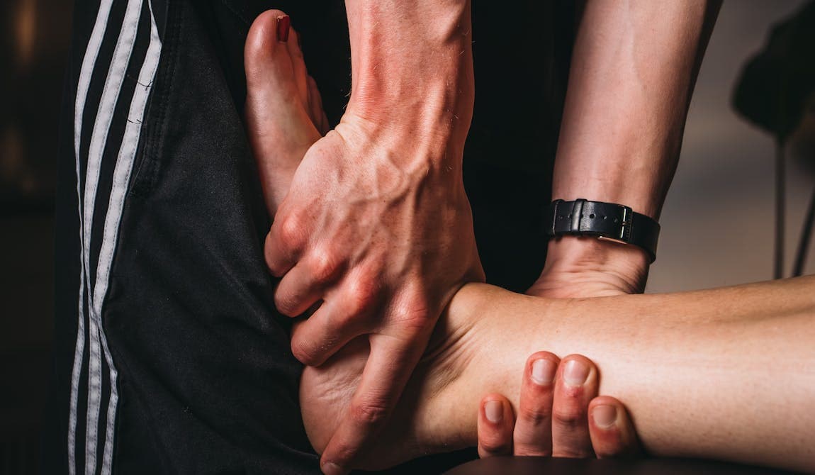 Physiotherapeut von PhysioSport Köln bei Untersuchung der Achillessehne eines Patienten.