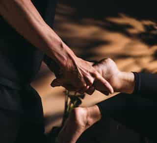 Physiotherapeut von Physiosport Köln behandelt bei einer Patientin die Triggerpunkte an der Fußsohle.