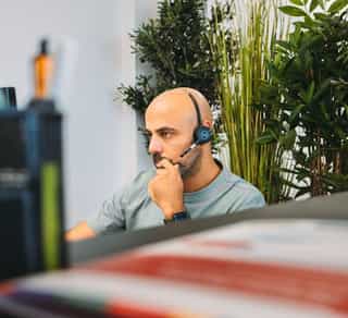 Zu sehen ist der Einblick in einen offenen Arbeitsplatz bei Physiosport Köln. Dort sitzt ein Mitarbeiter am Computer.