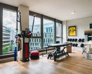 Zu sehen ist ein großer Behandlungsraum von PhysioSport Köln mit diversen Trainingsgeräten, Standort Mediapark.