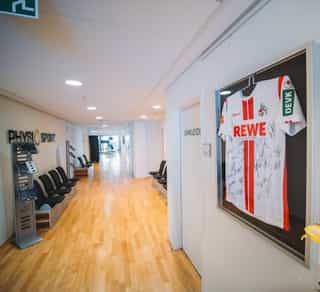 Zu sehen ist der Durchgangsbereich von PhysioSport Köln, Standort Mediapark, mit Spezialisten für die Behandlung von Schulterluxationen.