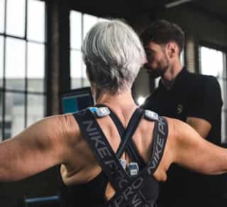 Zu sehen ist eine Patientin mit einem Physiotherapeuten von PhysioSport Köln bei gezielten Schulterübungen.