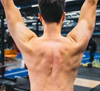 Zu sehen ist der kräftige Rücken und Schultermuskulatur eines Sportlers im Training bei PhysioSport Köln.