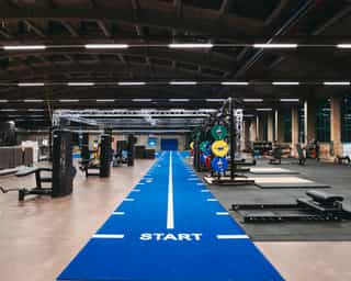 Zu sehen ist ein Einblick in eine Trainingshalle von PhysioSport Köln. Zu sehen sind diverse Trainingsstationen und Trainingsgeräte.