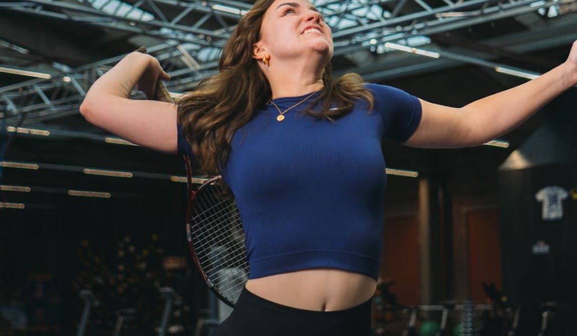 Sportlerin während Tennisübungen bei PhysioSport Köln nach Schulterbeschwerden.