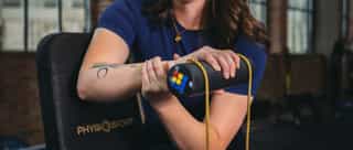Sportlerin bei individuellen Übungen gegen Tennisellenbogen in Trainingsräumen bei PhysioSport Köln.