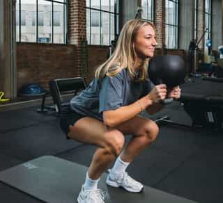 Zu sehen ist eine Sportlerin beim Krafttraining für Beine und Knie auf der Anlage von PhysioSport Köln.