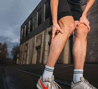 Sportler mit Waden- und Sehnenschmerzen nach Sport.